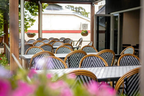 Custom Tiled Tabled And Jasmine Stools In Outdoor Dining Area At The Haus Restaurant