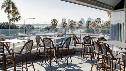 Jasmine Stools And Cross By S.C.A.B Table Base with Compact Laminate Table Tops In Outdoor Dining At Hotel Pacific
