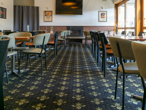 Indoor dining at The Hope Inn with upholstered dining chairs and timber tables.