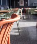 Close-up of orange chair and timber table.