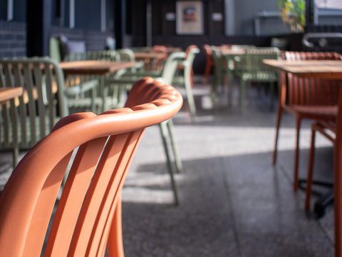 Close-up of orange chair and timber table.
