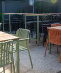 Courtyard dining with timber tables and chairs.