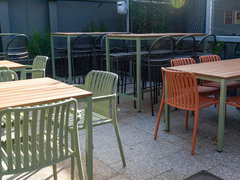 Courtyard dining with timber tables and chairs.