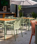 Outdoor dining under umbrellas with timber tables.
