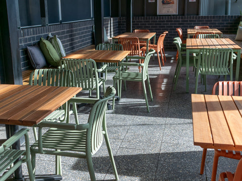 Outdoor terrace with timber tables and colourful chairs at The Hope Inn.